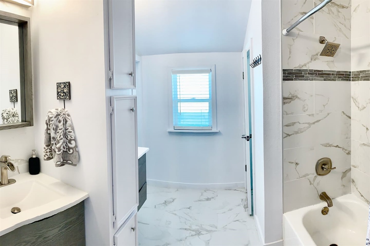 Newly renovated marble bath w/ dual sinks, shower/tub combo and private water closet